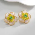 Dettaglio macro di orecchini a fiore dorati con petali bianchi e cristalli verdi - Stile Floreale Cuore Bianco Giallo Verde (S-E936)
