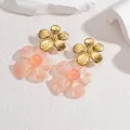 Detailopname van dubbele bloemoorbellen met gouden bloemblaadjes en roze hars hangers - Roze