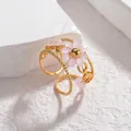 Détail d'une bague ajustable dorée perlée avec motif floral en perles roses mates - Rose Clair