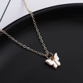 Detailweergave van de vlinderhanger ketting met witte schelpafwerking op zwarte achtergrond - Wit