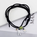 Detail of magnetic astronaut couple bracelets with woven rope and small planet charms - Black Pair