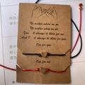 Vue détaillée des bracelets d'amitié tressés rouge et noir avec breloques cœur sur carte - Cœur (BS-0007)