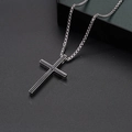 Macro detail of silver box chain and black inlaid cross pendant on a textured surface - Cross