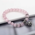 Details eines Perlenarmbands mit rosa Katzenaugensteinen und antikem hohlem Glockenanhänger - Hohlkugel-Anhänger / Rosa