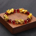 Gold-plated PiXiu bracelet with deep red garnet-style beads on a vintage wooden base - BNS-0078-8mm Red Glass Pixiu