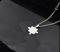 Poliertes silbernes Puzzleteil-Anhängerkette aus Edelstahl auf schwarzem Reflexhintergrund - Stil B O-Form Kette
