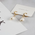 Gold plated hoop earrings featuring natural white conch shell pendants on jewelry card - White