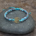 Blaues geflochtenes Lebensbaum Armband mit lila und cyan Steinen auf Kieselsteinen - Lila Blau Gold