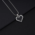 Primo piano dettagliato di una collana con pendente a cuore pixel retrò su fondo nero - Catena a Osso di Drago Pixel Stile Acciaio Inossidabile