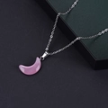 Detalle de un colgante de luna en piedra rosa con una cadena de metal plateado - Ojo de Gato Rosa