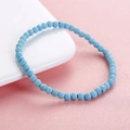 6mm faceted natural African turquoise beaded bracelet on a white ceramic plate and pink base - Turquoise