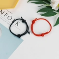 Detail von verstellbaren Paar-Armbändern mit Magnet-Herz-Anhänger auf Kinfolk-Magazin - Schwarz Rot