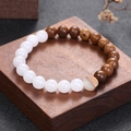 Zen-armband van kippenvleugelhout en witte stenen kralen op een houten standaard - Witte Steen En Hout