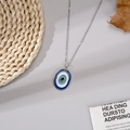 Minimalistische Halskette mit blauem Evil Eye Anhänger und Silberkette auf Strohmatte - Rechteckig Blau Silberkette