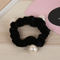 Dettaglio di un elastico per capelli in velluto nero con quattro grandi perle bianche - Nero