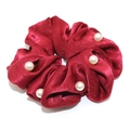 Elegant red velvet scrunchie with white pearl accents on a clean white background - Red