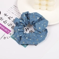Detailed shot of blue denim hair scrunchie with golden star patterns and lace accents - Light Blue Denim Star Pattern