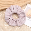 Vista detallada de un coletero plisado color púrpura claro con textura de tela suave en madera - Rosa