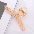 Pince à cheveux ambre en acrylique transparent avec ressort doré sur fond blanc - Orange transparent
