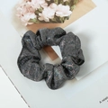 Macro detail of sparkly black fabric hair scrunchie with glitter and elegant folds - Black