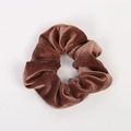Gros plan détaillé montrant la texture du chouchou en velours marron sur fond blanc - Café