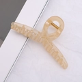 Pince à cheveux élégante beige crème translucide avec ressort doré sur fond texturé - Beige Translucide