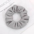 Detailed view of silver mesh scrunchie with elastic corn grain texture on magazine - Silver Gray