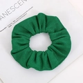 Detail of emerald green knitted scrunchie with corn kernel texture on fashion magazine - Emerald Green