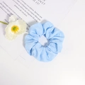Detalle de coletero azul claro con textura de cuadros sobre un fondo blanco minimalista - Azul