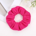 Detailed close-up of a vibrant fuchsia scrunchie with textured corn grain woven fabric - Flamingo Pink