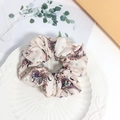 Boho-Haargummi mit Paisleymuster in Cremeweiß auf einem dekorativen Keramikteller - Weiß