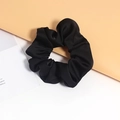 Vue détaillée d'un chouchou en satin noir brillant avec texture plissée douce et élastique - Noir
