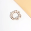 Close-up of champagne silk satin hair scrunchie with elegant glossy texture on white background - Light Coffee