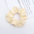 Dettaglio di un elastico per capelli in tessuto jacquard a fiori giallo chiaro su fondo bianco - Giallo