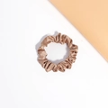 Macro detail of champagne satin hair scrunchie showing glossy silk texture and elegant folds - Brown