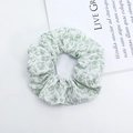 Detail shot of light green quilted floral scrunchie with French style flower pattern - Green