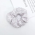 Dettaglio di scrunchie bianco a fiori viola con tessuto increspato e motivo floreale - Viola