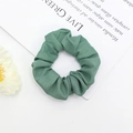 Détail d'un chouchou en tissu vert sur fond blanc avec des fleurs séchées - Vert Rétro (6)