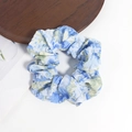Detailansicht eines großen Haargummis mit blau-gelbem Blumenmuster im Ölgemäldestil - Blau