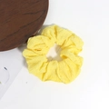 Dettaglio di un elastico per capelli giallo acceso in seersucker con trama a bolle - Giallo