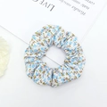 Detailopname van een scrunchie met blauwe bloemenprint en zachte geplooide stoffen textuur - Blauw Bloemen