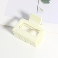 Vue détaillée d'une pince à cheveux carrée crème avec une finition mate et design creux - Blanc Brillant