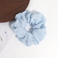Elastico per capelli azzurro in tessuto seersucker su sfondo bianco minimalista - Blu