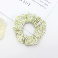 Detailed view of floral scrunchie with green and yellow patterns on a fresh background - Green Yellow Floral