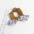 Détail d'un chouchou marron à fleurs avec nœud oreilles de lapin sur fond blanc pur - Style Floral Bleu Violet Patchwork Marron