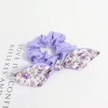 Détail d'un chouchou violet avec nœud à fleurs montrant la texture délicate du tissu - Style Floral Violet Patchwork Mauve
