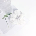 Dettaglio di elastico per capelli in organza bianca con perline su pagina di rivista - Bianco