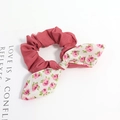 Détail du chouchou rose poudré avec nœud floral et carte décorative sur fond blanc épuré - Style Floral Rose Patchwork Vieux Rose