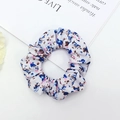 Detailed shot of a floral fabric scrunchie with pink and blue blossoms on white background - Blue Pink Floral