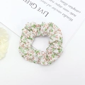 Detailed close-up of a floral print scrunchie with soft pastel green and brown patterns - Green Brown Floral